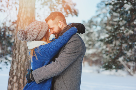happy loving couple walking in snowy winter forest, spending christmas vacation together. Outdoor seasonal activities. Lifestyle capture.の写真素材