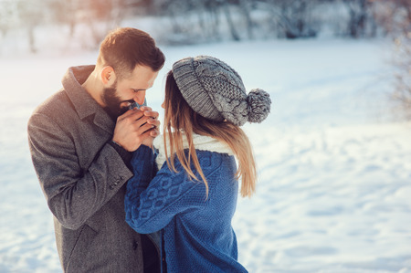 lifestyle shot of young happy couple walking in snowy forest, spending winter vacation outdoorsの写真素材