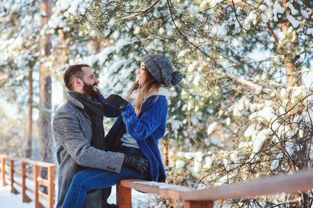 happy loving couple walking in snowy winter forest, spending christmas vacation together. Outdoor seasonal activities. Lifestyle capture.の写真素材