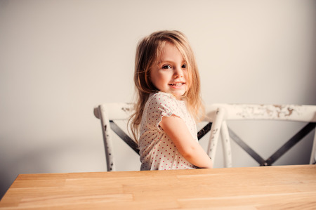 indoor portrait of cute toddler girl sitting in kitchenの写真素材