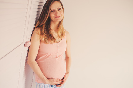 indoor lifestyle portrait of happy pregnant womanの写真素材