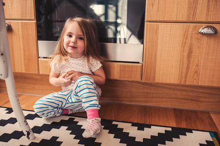 cute toddler girl playing in kitchen, real life lifestyleの写真素材