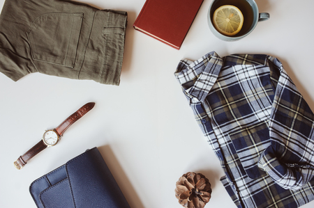 summer or autumn woman casual fashion set flat lay with copy space. Plaid shirt, blue cross body bag  and khaki pants on white background. Stylish outfit top view.の写真素材