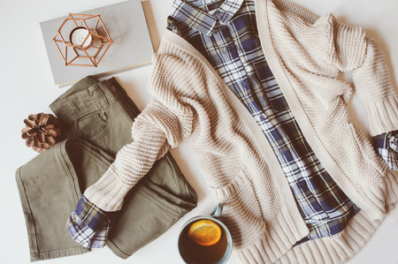 cozy autumn woman casual outfit set flat lay. Plaid shirt, knitted sweater, blue cross body bag  and khaki pants on white background. Stylish fashion, top view.の写真素材