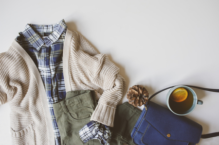 autumn woman casual fashion set flat lay with copy space. Plaid shirt, knitted sweater, blue cross body bag  and khaki pants on white background. Stylish outfit top view.の写真素材