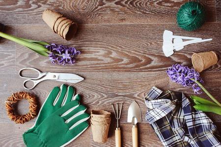 spring preparations for planting flowers top view. Gardener seasonal table with gloves, flowers, garden labels, peat pots and tools. Flat lay with copy space.の写真素材