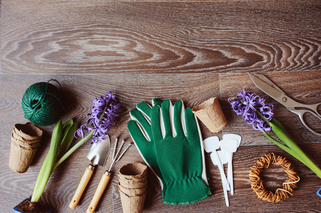 spring preparations for planting flowers top view. Gardener seasonal table with gloves, flowers, garden labels, peat pots and tools. Flat lay with copy space.の写真素材
