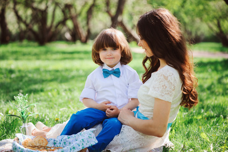 happy family on picnic for mothers day. Mom and toddler son eating sweets outdoor in spring or summer park. の写真素材