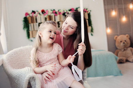happy family sitting on chair at home. Casual lifestyle capture of mother and toddler daughterの写真素材