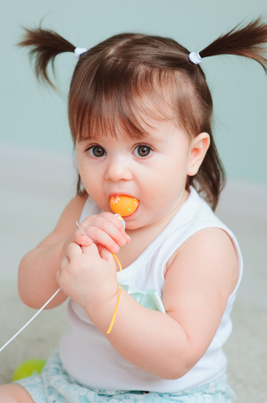 close up indoor portrait of cute happy baby girl playing with easter decorationsの写真素材