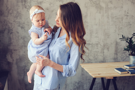 happy mother and baby playing at home in bedroom. Cozy family lifestyle in modern scandinavian interior. の写真素材
