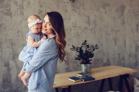 happy mother and baby playing at home in bedroom. Cozy family lifestyle in modern scandinavian interior. の写真素材