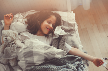 happy kid girl walking up in early morning in her roomの写真素材