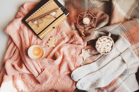 cozy Christmas table with seasonal fashion clothes, hot cocoa and candles. Hygge concept