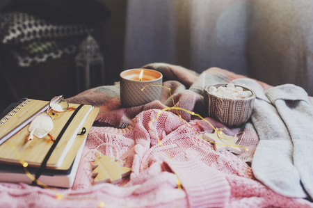 cozy autumn morning at home. Still life details with cup of hot cocoa, candle, sketch book with herbarium and warm sweater. Scandinavian hygge conceptの写真素材