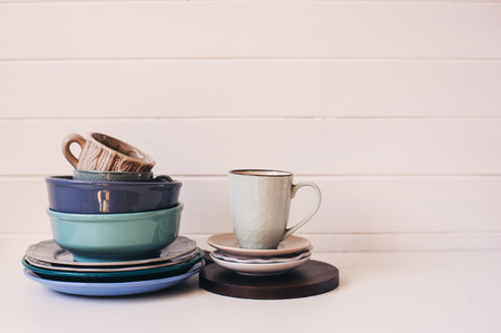 natural rustic handmade kitchenware on wooden background. Ceramic dished and cups in neutral tones,...