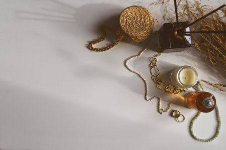Minimalist home aesthetics. Fashion jewelery and candles setting on white background. Feminine trendy homeの写真素材