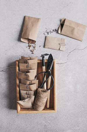 spring preparations for seeding. Top view of handmade craft paper bags , with seeds on gray background. Seeds organization.の素材 [FY310205224921]