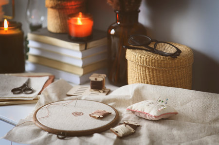 cross stitch embroidery with handcraft accessories and candles. Hobby for winter and autumn cozy evenings at home. Slow living.の写真素材