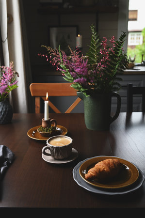coffee and croissant in rustic country cottage. Cozy evening home interior in brown dark colorsの写真素材