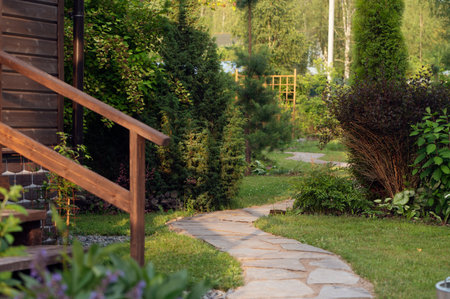 summer ornamental cottage garden view with stone pathway and wooden porchの写真素材