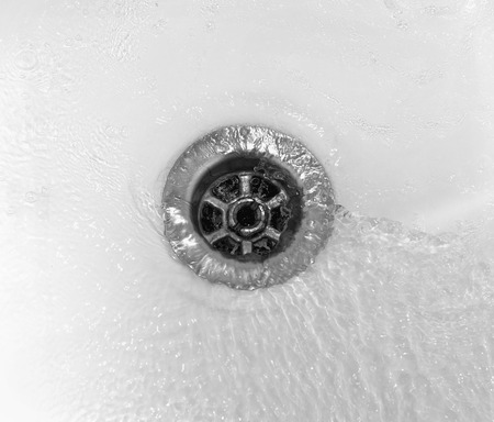 Water flows into the drain enamel sinkの写真素材