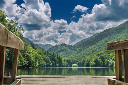 pier on a lake in the woods cloudy skyの写真素材