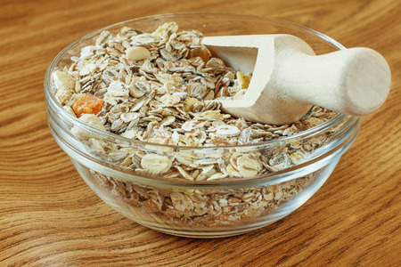 muesli in glass bowl and a wooden scoopの写真素材