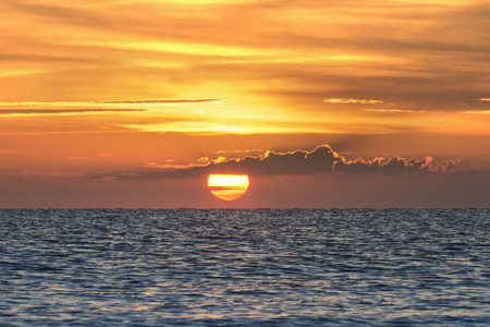 sunrise over the sea, beautiful lighting, backlit clouds in the waterの写真素材