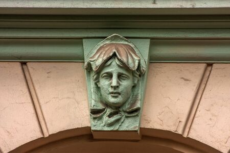 Mascaron in the form of young man on building in Kyiv, Ukraine