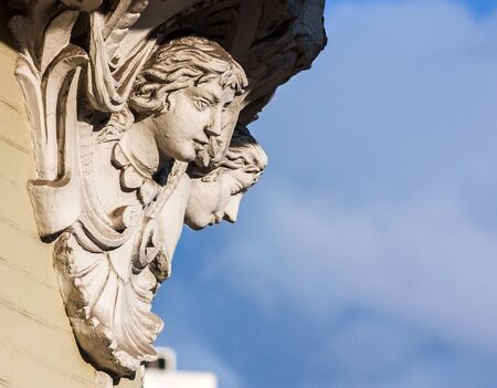 Mascarones over blue sky on building in Kyiv, Ukraine