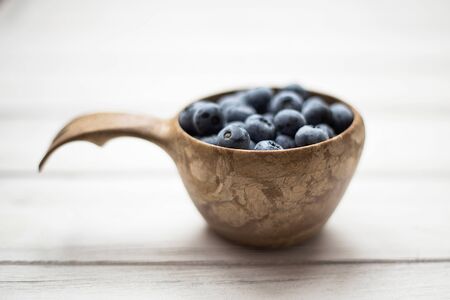 Wooden bowl with summer blueberries close up. Macroの写真素材