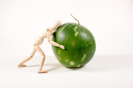 Overloaded Work in a compositon of wooden mannequion and watermelon on a white backgroundの写真素材