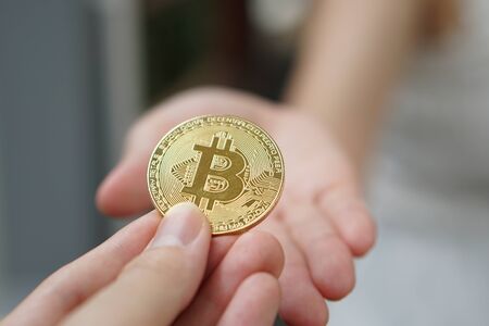closeup hand holding bitcoin. transfer bitcoin from hand to hand