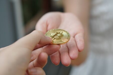 closeup hand holding bitcoin. transfer bitcoin from hand to handの写真素材
