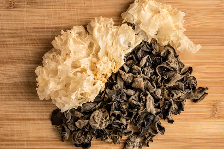 White fungus and black fungus on wooden boardの写真素材