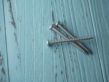 screw on wooden blue background