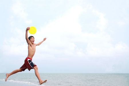 happy young man jumping at the beachの写真素材
