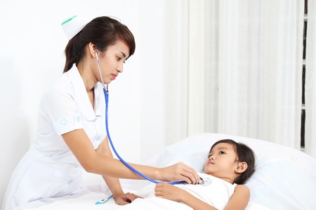 Asian nurse examining a sick childの写真素材