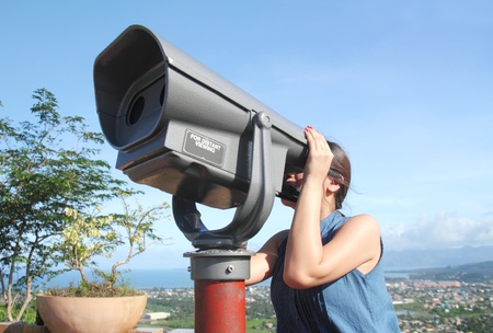 Lady tourist looking through a telescope.の写真素材