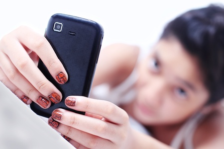 Young lady holding a cellphone.Close up.Narrow DOF.の写真素材