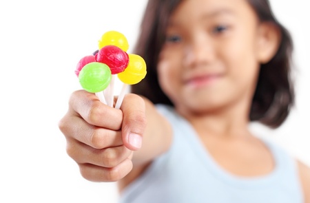 Young girl showing a sweet and colorful lollipops.の写真素材