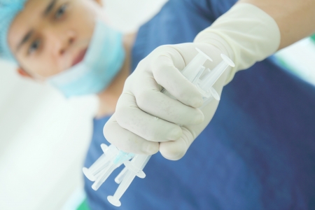 Health worker holding a bunch of used syringes.の写真素材