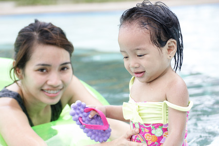A watchful lady and a little girl in the swimming pool.の写真素材