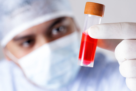 Scientist studying a tube with a chemical for vaccine research. Close up.の写真素材