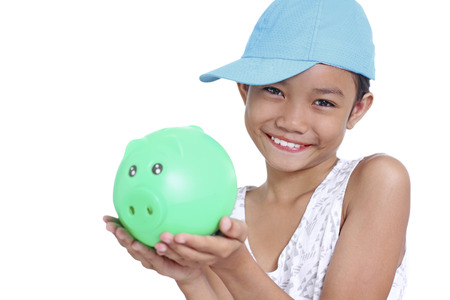 Young happy asian girl holding a piggy bank. Isolated in white background.の写真素材