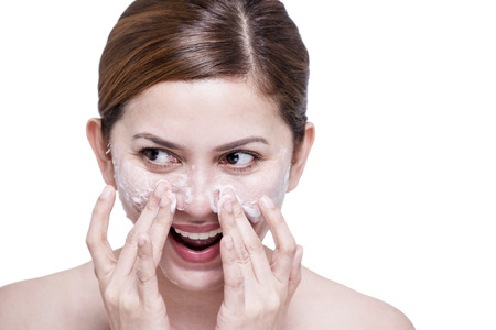 Beautiful lady cleaning her face with facial soap. Isolated in white backround.の写真素材