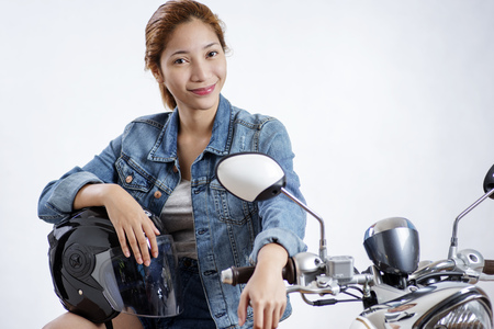 Smiling young lady sitting on a motorcycle.の写真素材