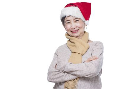 Portrait of a smiling senior lady wearing a Santa hat. Isolated in white background.の写真素材