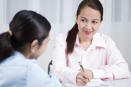 Adult woman taking notes during a job interview.の写真素材